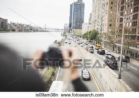 "Young woman standing on footbridge, taking photographs, rear view" View Large Photo Image Picture - "Young woman standing on footbridge, taking photographs, rear view". Fotosearch