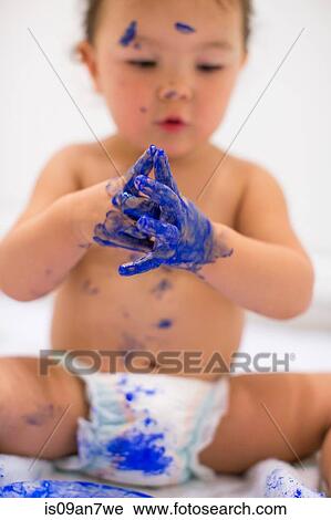 Baby girl dabbling with finger paints in white kitchen View Large Photo Image Stock Image - Baby girl dabbling with finger paints in white kitchen. Fotosearch