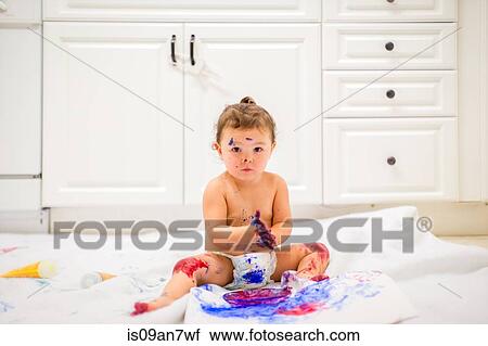 Baby girl dabbling with finger paints in white kitchen View Large Photo Image Stock Image - Baby girl dabbling with finger paints in white kitchen. Fotosearch