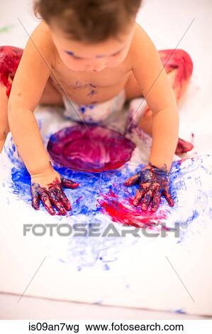 Baby girl dabbling with finger paints in white kitchen View Large Photo Image Stock Image - Baby girl dabbling with finger paints in white kitchen. Fotosearch