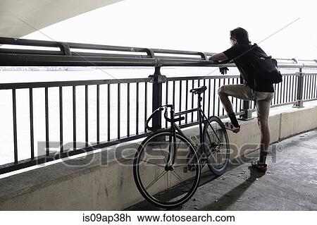 Stock Image - Bike messenger taking break. Fotosearch