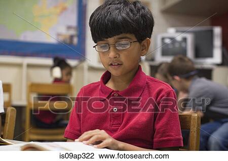 Boy reading book in classroom View Large Photo Image Stock Image - Boy reading book in classroom. Fotosearch