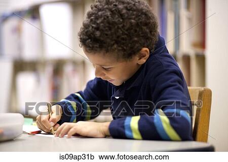 Boy writing in classroom View Large Photo Image Stock Image - Boy writing in classroom. Fotosearch