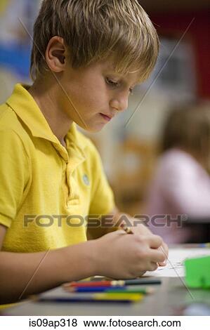 Boy writing in classroom View Large Photo Image Stock Photo - Boy writing in classroom. Fotosearch