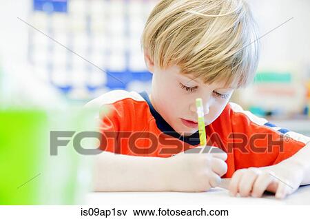Boy writing in exercise book in classroom View Large Photo Image Stock Photo - Boy writing in exercise book in classroom. Fotosearch