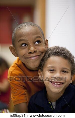 Stock Image - Boys smiling in classroom. Fotosearch