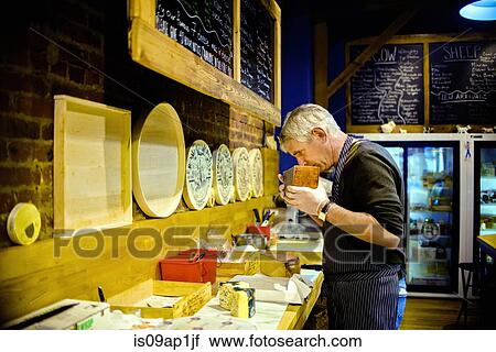 Cheesemonger smelling cheese View Large Photo Image Stock Image - Cheesemonger smelling cheese. Fotosearch