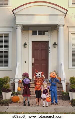 Children covering face with Jack O' Lantern bucket in front of house View Large Photo Image Stock Image - Children covering face with Jack O' Lantern bucket in front of house. Fotosearch