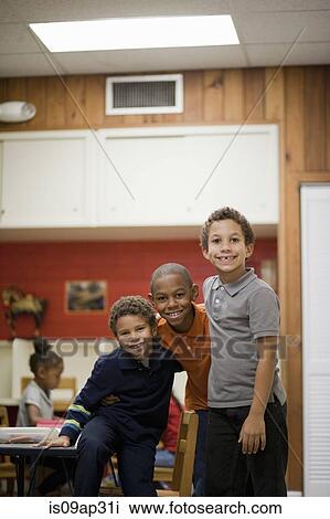 Stock Image - Children smiling in classroom. Fotosearch