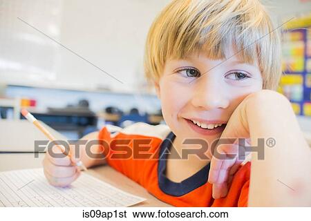 Close up portrait of boy writing in exercise book in classroom View Large Photo Image Stock Photograph - Close up portrait of boy writing in exercise book in classroom. Fotosearch