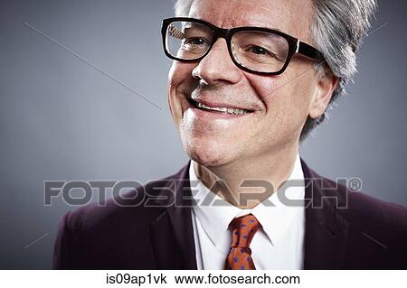 Stock Image - Close up studio portrait of smiling mature businessman. Fotosearch