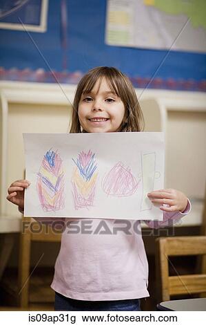 Girl showing off drawing in classroom View Large Photo Image Stock Image - Girl showing off drawing in classroom. Fotosearch