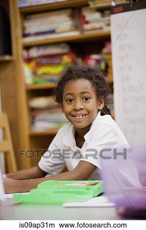 Picture - Girl smiling in classroom. Fotosearch