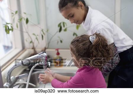 Girl watching toddler washing hands View Large Photo Image Stock Image - Girl watching toddler washing hands. Fotosearch