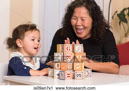 Stock Image - Grandmother and granddaughter building blocks. Fotosearch