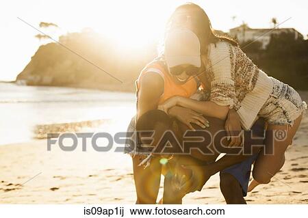 Stock Image - Group of friends fooling around on beach. Fotosearch