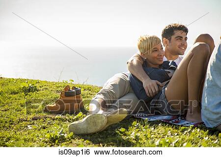 Stock Photograph - Group of friends relaxing on grass. Fotosearch