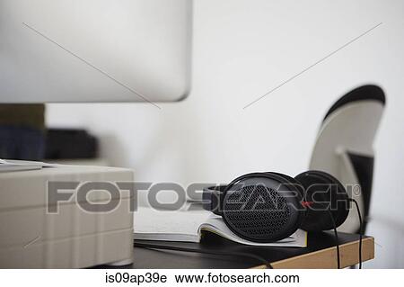 Stock Image - Headphones on edge of desk. Fotosearch