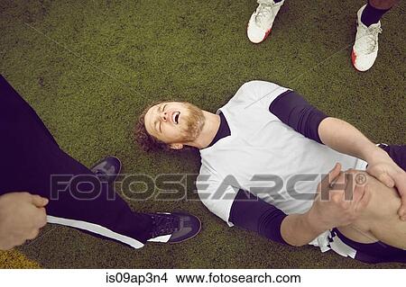 Picture - Injured male soccer player on soccer pitch. Fotosearch