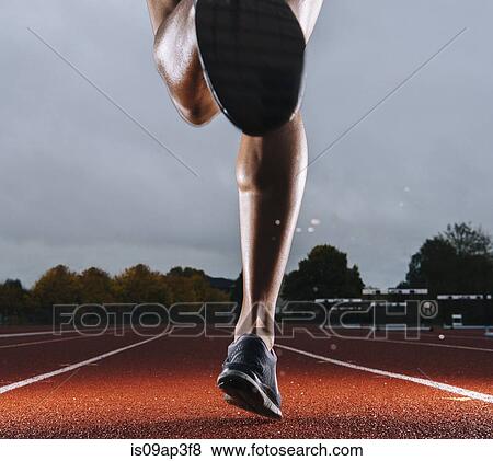 Legs of young female athlete running on race track View Large Photo Image Stock Photo - Legs of young female athlete running on race track. Fotosearch