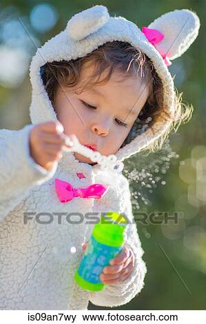 Stock Photo - Little girl blowing bubbles. Fotosearch