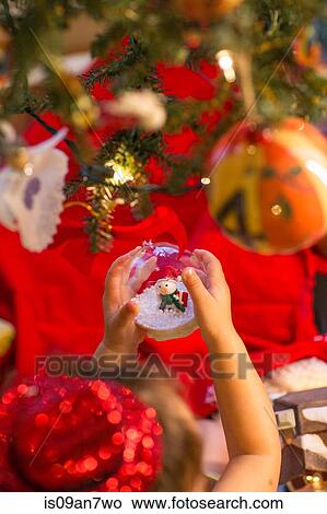 Little girl holding snow globe ornament in hand View Large Photo Image Picture - Little girl holding snow globe ornament in hand. Fotosearch