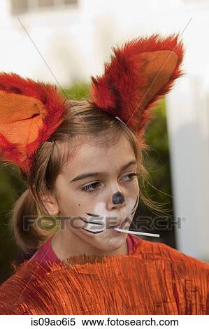 Stock Photography - Little girl in fox costume sucking on lollipop. Fotosearch