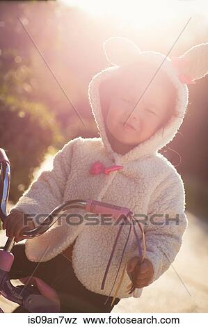 Little girl learning to ride tricycle View Large Photo Image Stock Photo - Little girl learning to ride tricycle. Fotosearch