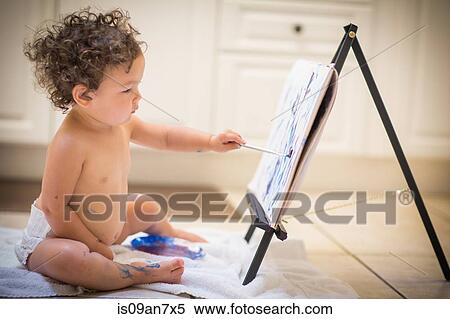 Stock Photography - Little girl painting in kitchen. Fotosearch