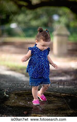 Little girl walking in puddle at park View Large Photo Image Stock Photograph - Little girl walking in puddle at park. Fotosearch