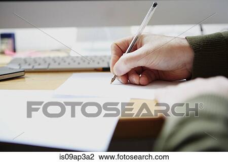 Stock Image - Man writing on paper with pen. Fotosearch