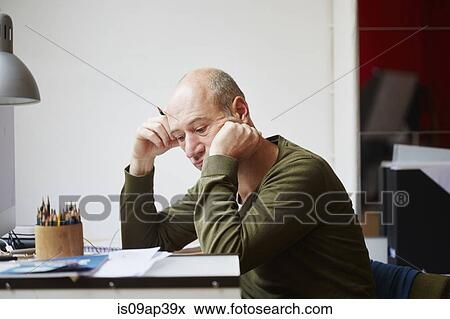 Mature man at desk leaning on elbow View Large Photo Image Stock Photo - Mature man at desk leaning on elbow. Fotosearch