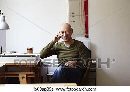 Mature man on the phone in creative studio View Large Photo Image Stock Photograph - Mature man on the phone in creative studio. Fotosearch