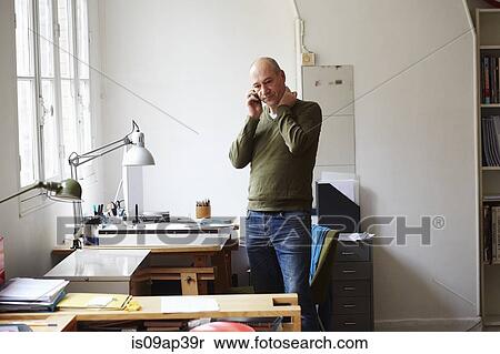 Mature man on the phone in creative studio View Large Photo Image Stock Photography - Mature man on the phone in creative studio. Fotosearch