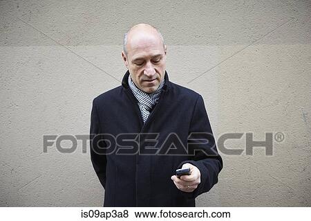 Mature man using smartphone View Large Photo Image Stock Photo - Mature man using smartphone. Fotosearch
