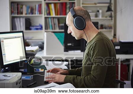 Mature man working in creative studio wearing headphones View Large Photo Image Picture - Mature man working in creative studio wearing headphones. Fotosearch