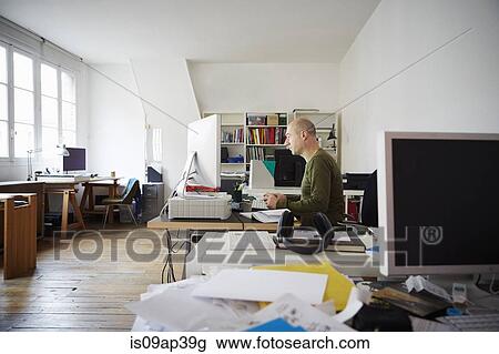 Stock Image - Mature man working in creative studio. Fotosearch