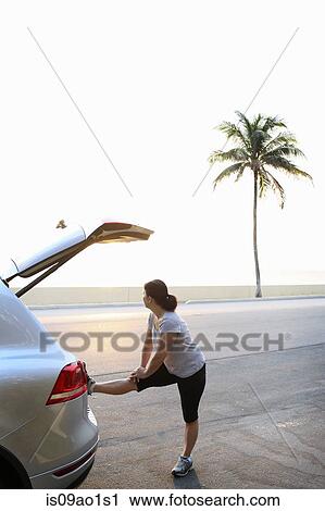Stock Image - "Mature woman warming up for exercise, Palm Beach, Florida, USA". Fotosearch