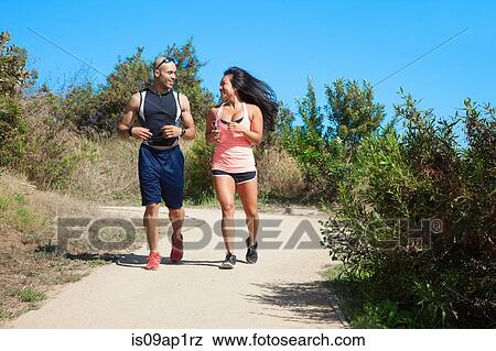 Mid adult man and woman jogging together along rural pathway View Large Photo Image Stock Photo - Mid adult man and woman jogging together along rural pathway. Fotosearch