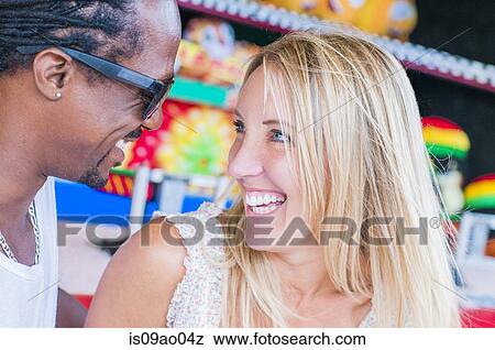 Multi ethnic mature couple laughing at amusement park View Large Photo Image Stock Photo - Multi ethnic mature couple laughing at amusement park. Fotosearch