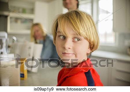 Stock Photo - Portrait of boy looking sideways in kitchen. Fotosearch