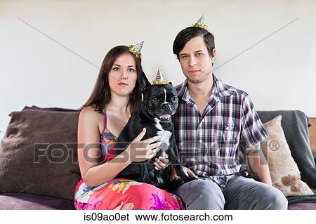 Portrait of couple sitting on sofa with dog and deadpan expressions View Large Photo Image Stock Photograph - Portrait of couple sitting on sofa with dog and deadpan expressions. Fotosearch