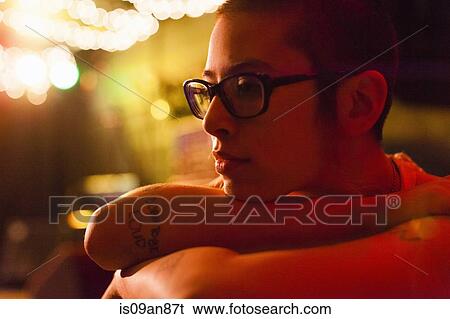 Stock Photograph - "Portrait of punk girl, resting head on arms, pensive expression". Fotosearch