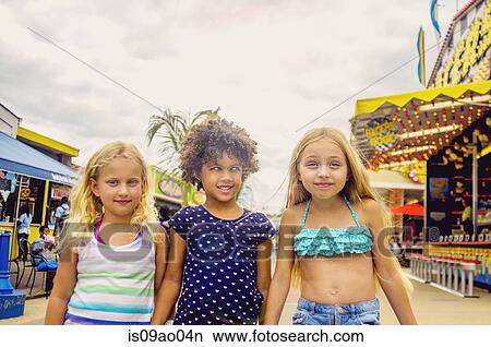 Portrait of three girls at amusement park View Large Photo Image Picture - Portrait of three girls at amusement park. Fotosearch