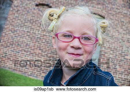 Stock Image - Portrait of young girl wearing pink glasses. Fotosearch