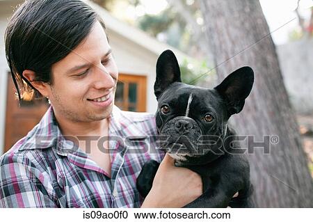 Portrait of young man carrying dog View Large Photo Image Stock Image - Portrait of young man carrying dog. Fotosearch