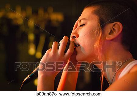 "Punk girl singing into microphone, eyes closed" View Large Photo Image Picture - "Punk girl singing into microphone, eyes closed". Fotosearch
