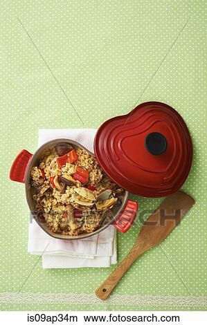 Picture - "Rice with meat, seafood and vegetables in cast iron cookware". Fotosearch
