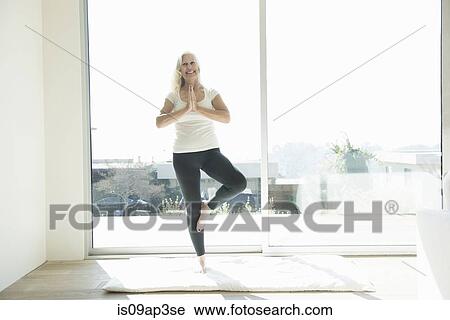 Stock Image - Senior woman in yoga pose. Fotosearch