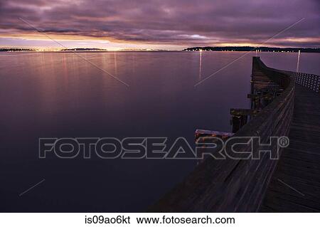 Stock Photograph - "Silhouetted view of winding wooden pier over Puget Sound at night, Seattle, Washington State, USA". Fotosearch